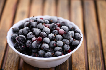 Frozen mixed berries as background. Currant mulberry texture pattern. Diet vegetarian food in winter.