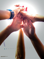 Close up young people putting their hands together/Team work business team showing unity with their...
