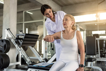 Fototapeta na wymiar Physiotherapist helping old senior woman in physical center. elderly health lifestyle concept.