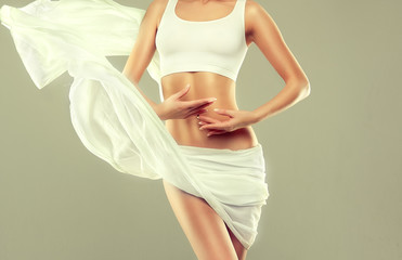  Perfect slim toned young body of the girl . An example of sports , fitness or plastic surgery and aesthetic cosmetology.


