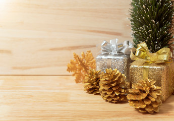 golden pine cones glittered christmas and gift box decoration on wood table background. copy space.