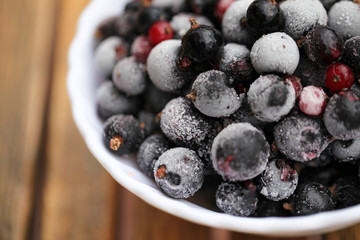 Frozen mixed berries as background. Currant mulberry texture pattern. Diet vegetarian food in winter.