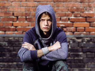 dangerous teenager on brick wall background, teen problems concept