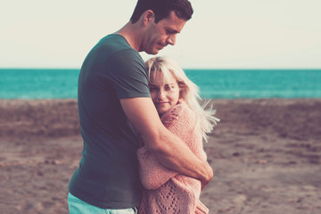 nice caucasian couple in vacation leisure outdoor. enjoy and smile in love together playing and hugging full of lovely thoughts. beach place and ocean horizon colored in background