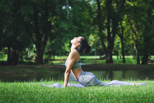 Fitness asian woman doing yoga in park