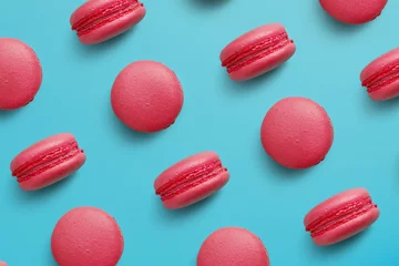 Foto op Plexiglas Bitterkoekjes op gekleurde achtergrond, een patroon van kleurrijke franse koekjes macarons. Beige, bruine Franse koekjes macarons op rode achtergrond. Cadeau voor Valentijnsdag © Aliaksei