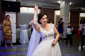 Crazy dance of a young bride in the dance floor