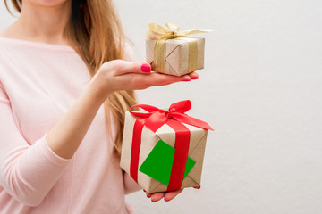 Woman holding a box with a gifts and business card to the camera, front view, close up, background with copy space, for advertising or slogan