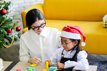 Family decorating a Christmas tree and Mother giving Christmas Gift,Christmastime celebration and Happy new year.