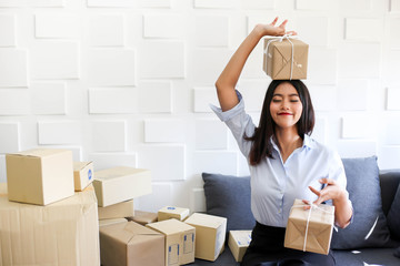 Young asian girl is freelancer Start up small business owner writing address on cardboard box at workplace,Shipping shopping online small business entrepreneur SME or freelance