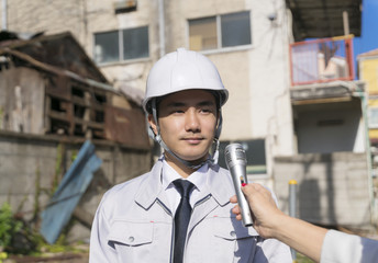 インタビューを受けるビジネスマン・ヘルメット