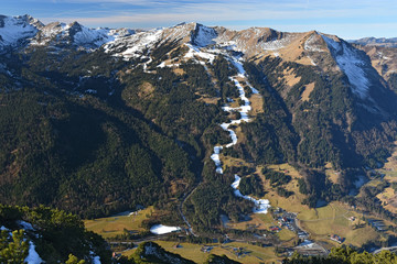 Artificially snow-covered slopes in winter with little snow near Oberstdorf, Allgaeu Alps, Germany.