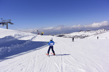 Fototapeta na wymiar Esquiadores montando desde las cimas de la sierra nevada.