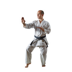 On white isolated background adult athlete doing formal karate exercises