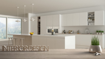 Wooden table, desk or shelf with potted grass plant, house keys and 3D letters making the words interior design, over blurred minimalist kitchen, project concept copy space background