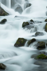Langzeitbelichtung eines Gerbirgsflusses in Norwegen mit Felsen im Bachlauf, Norwegen