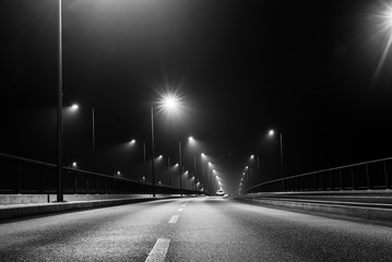 Bridge at night, black and white, foggy road, lanterns and fog
