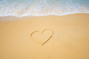 Fototapeta na wymiar heart shape on sand at the sea sunny day. subject is blurred.