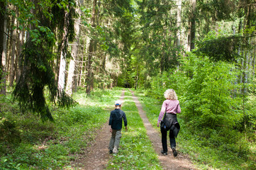 Obraz premium Mother and son walk together through the forest