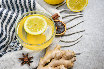 Ginger tea with lemon slice and glass cup. Healthy tea time with fresh ginger root. Winter scene,...