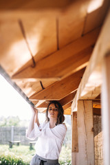 Atmospheric portrait of a beautiful lonely girl walking around a wooden house on the water at the lake