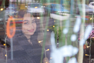 Portrait of a European woman sitting in a cafe looking out the window.