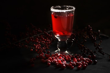 Cranberry juice and cranberries on a black background. Winter drink.
