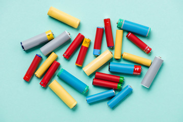 Top view of colorful batteries scattered on blue background