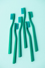 Top view of plastic turquoise toothbrushes arranged on blue background