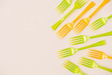 Top view of colorful plastic forks on pink background