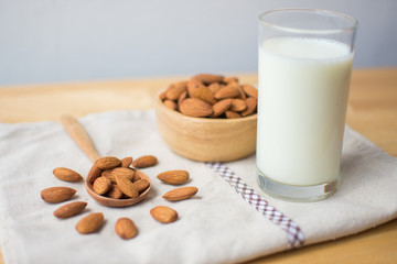 almond and milk on wooden table. soft focus.