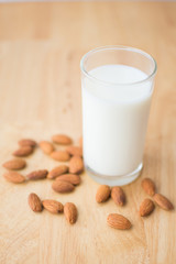 almond and milk on wooden table. soft focus.