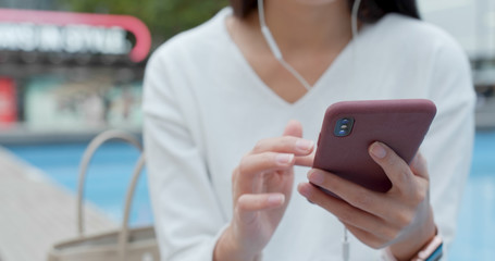 Woman listen to music on earphone in city