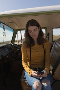 Woman using mobile phone in van