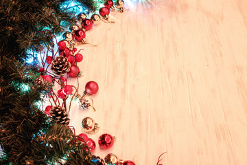 Christmas or New Year background with fir tree branches decorated with cones and red balls on wooden table. Flat lay with copy space
