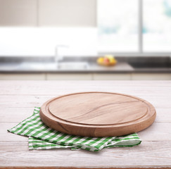 Empty pizza board with tablecloth on the table and kitchen interior background