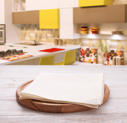 Empty pizza board with tablecloth on the table and kitchen interior background