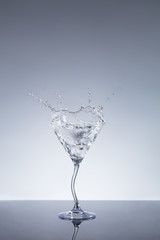 Glass of Martini drink with splashing gin around