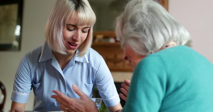 Female Carer Serving Lunch To Senior Woman At Home