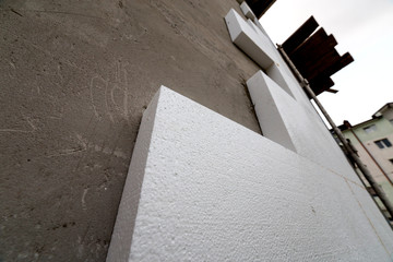 Close-up detail of plastered house wall with rigid styrofoam insulation. Modern technology, construction, renovation, energy saving, alternative for mineral wool, warm comfortable house concept.