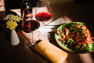 Two glasses with red wine and tasty breakfast on the table