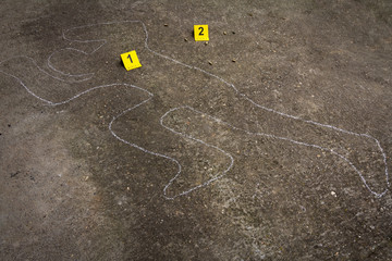 Crime scene. Shape of body on concrete texture. Bullet shell next to