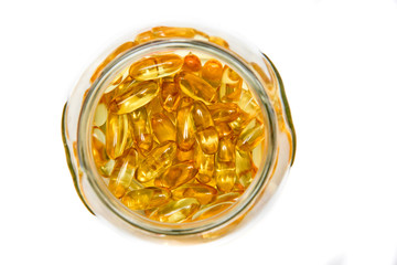 Capsules with omega3 in a glass vessel. View from above. Close-up.