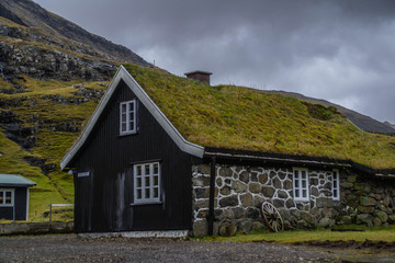 Fototapeta na wymiar Panorama landscape scenic view of historic traditional houses with grass (turf) roof in village of Saksun, Stroymoy Island. Tourist popular attraction/destination in Faroe Islands (Denmark) 