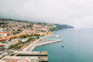 Aerial view of the Funchal old town - the capital of Madeira island during cloudy weather. Small...