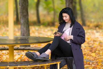 Young woman relaxing at a circular table in a park