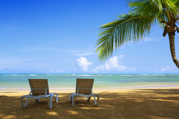Naklejka na ściany i meble Two beach lounge on a beautiful tropical beach .