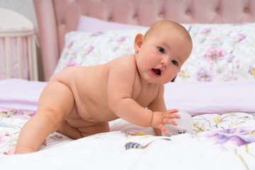 Little baby crawling across parents bed