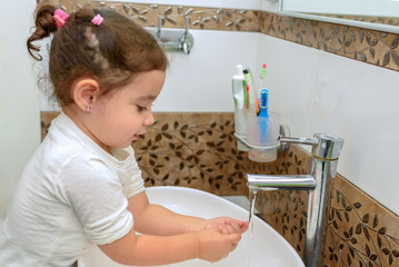 Obraz na płótnie Canvas Little toddler girl in bathroom washing hands. Cute sweet baby play in water. Healthy, Child's Hygiene concept.