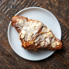 Fresh croissant for breakfast on dark rustic wooden table with copy space. Flat lay. Top view
